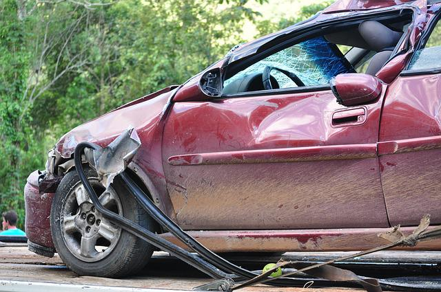 What to do after a car accident in Georgia: driver photographing crash damage on an Atlanta road
